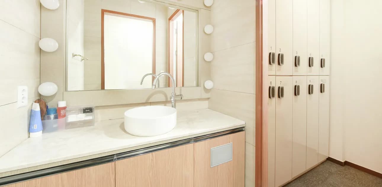 Powder room with a mirror, wash basin and lockers