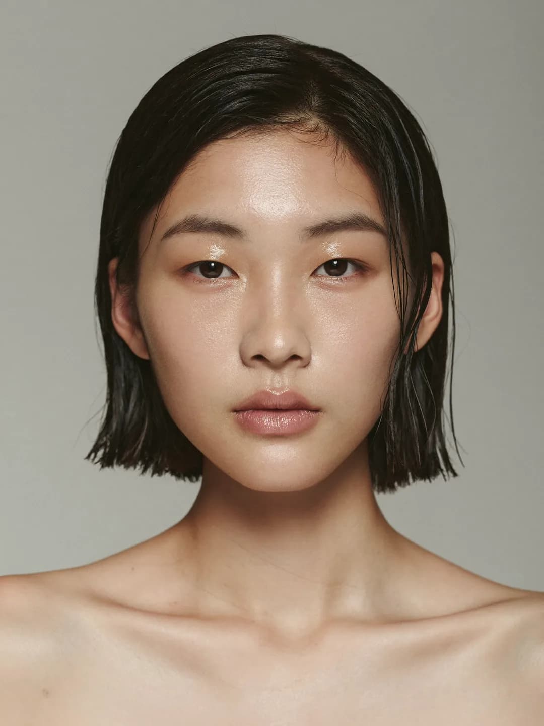 Potret seorang wanita Korea dengan rambut bob lurus paras dagu dan bahu yang terdedah, berlatarkan warna kelabu lembut.